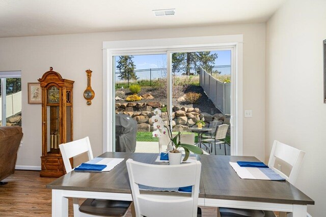 dining area with wood finished floors and visible vents
