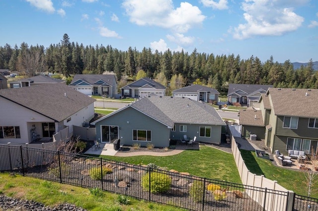 back of house featuring a yard, a patio, a residential view, and a fenced backyard