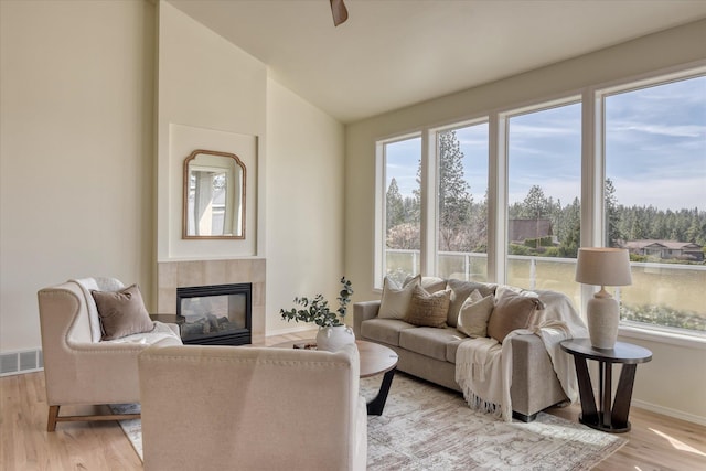 1814 S Viewcrest Ln Unit 1814, Spokane Valley, WA 99212 - living area featuring a tile fireplace, light wood-style floors, lofted ceiling, baseboards, and ceiling fan