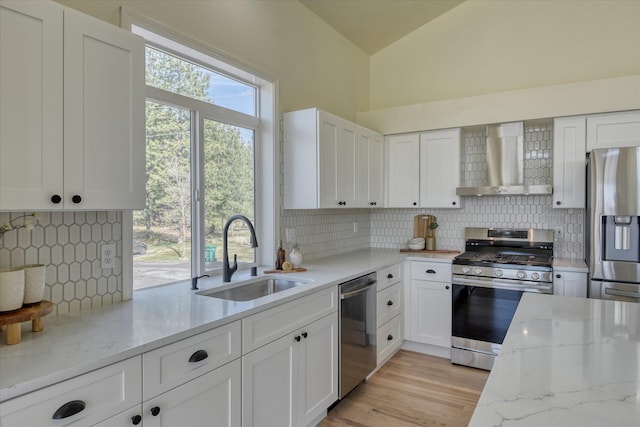 1814 S Viewcrest Ln Unit 1814, Spokane Valley, WA 99212 - kitchen featuring stainless steel appliances, a sink, wall chimney range hood, decorative backsplash, and vaulted ceiling