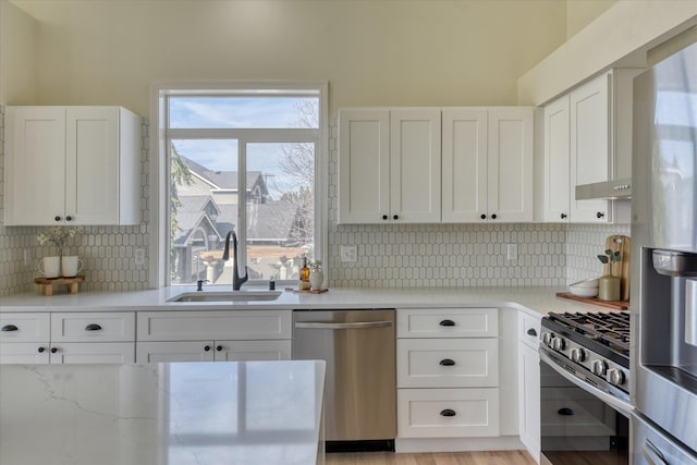 1814 S Viewcrest Ln Unit 1814, Spokane Valley, WA 99212 - kitchen featuring appliances with stainless steel finishes, a sink, white cabinetry, tasteful backsplash, and light stone countertops