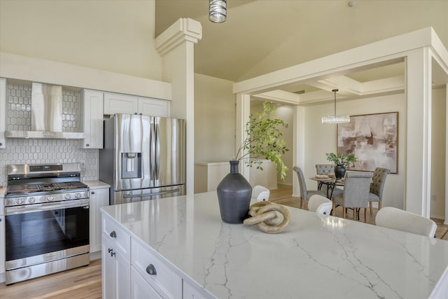 1814 S Viewcrest Ln Unit 1814, Spokane Valley, WA 99212 - kitchen with stainless steel appliances, wall chimney exhaust hood, light stone countertops, white cabinets, and lofted ceiling