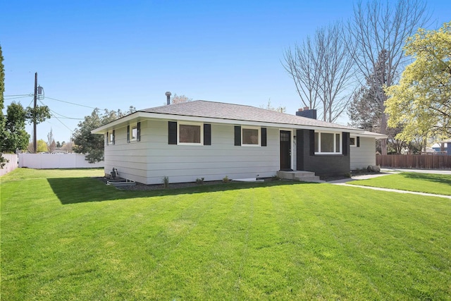 ranch-style home with fence, a chimney, and a front yard