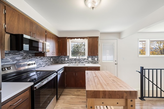 11904 E 22nd Ave, Spokane Valley, WA 99206 - kitchen with stainless steel appliances, a sink, backsplash, and light wood finished floors