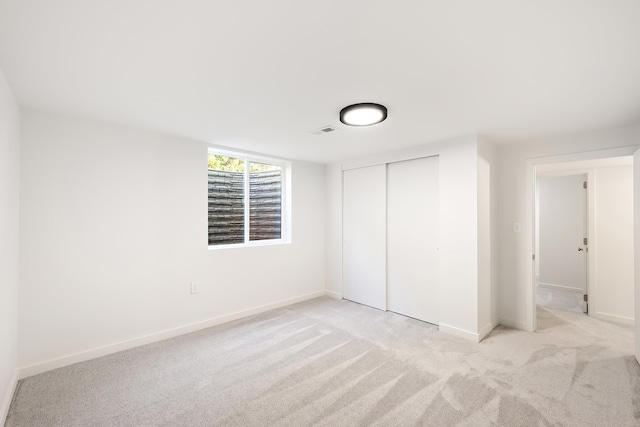unfurnished bedroom featuring baseboards, visible vents, light carpet, and a closet
