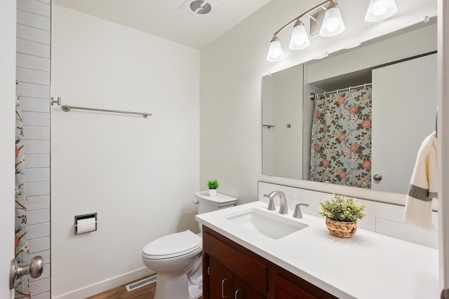 11904 E 22nd Ave, Spokane Valley, WA 99206 - bathroom featuring vanity, toilet, wood finished floors, baseboards, and curtained shower