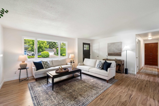 11904 E 22nd Ave, Spokane Valley, WA 99206 - living room featuring a textured ceiling, light wood-type flooring, and baseboards