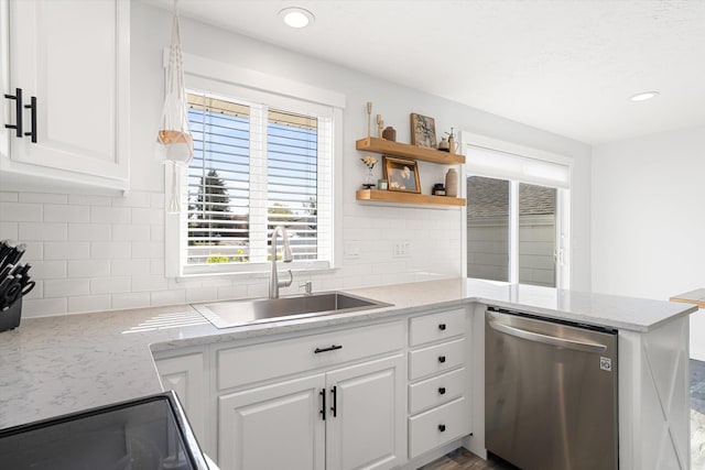 kitchen with a sink, dishwasher, white cabinets, and decorative backsplash