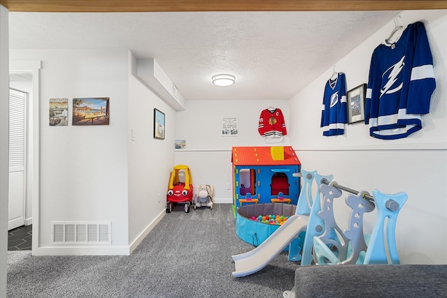 rec room featuring baseboards, visible vents, a textured ceiling, and carpet