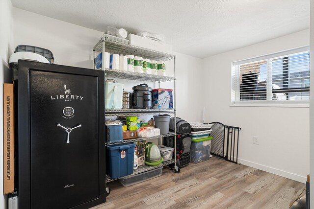 miscellaneous room featuring a textured ceiling, baseboards, and light wood-style floors