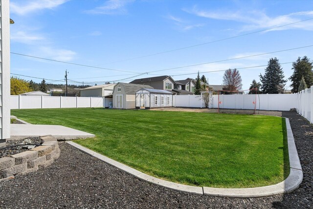 view of yard with an outdoor structure and a fenced backyard