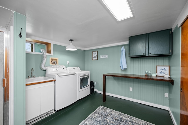 clothes washing area featuring a sink, cabinet space, independent washer and dryer, and baseboards