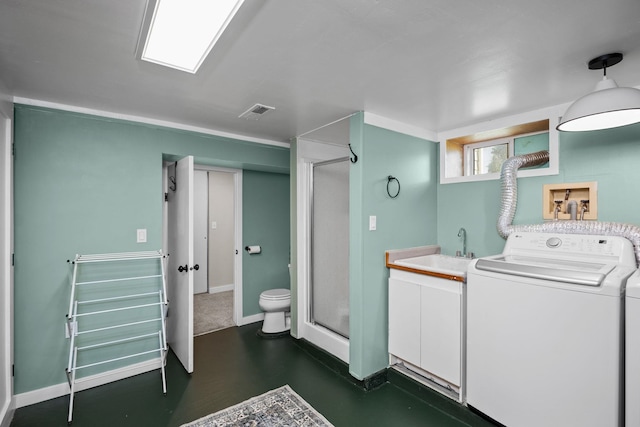 washroom featuring a sink, laundry area, washer / dryer, visible vents, and baseboards
