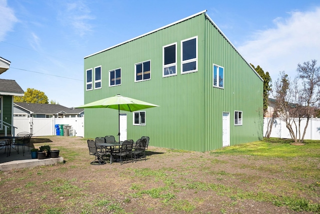 back of property with a patio, a fenced backyard, and a gate