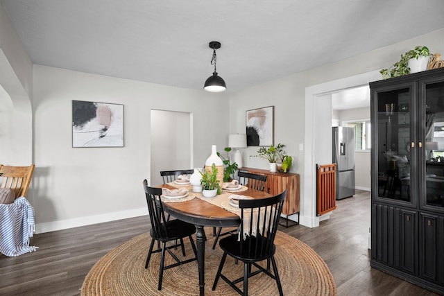 dining space featuring dark wood-style floors and baseboards