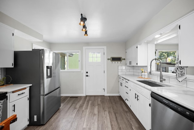kitchen with white cabinets, appliances with stainless steel finishes, light countertops, and a sink