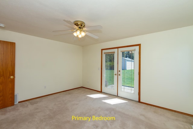 carpeted empty room featuring french doors, ceiling fan, visible vents, and baseboards