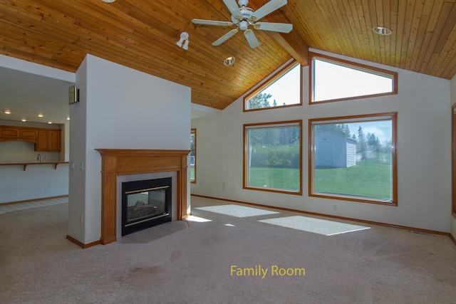 unfurnished living room with ceiling fan, carpet floors, a fireplace with flush hearth, and plenty of natural light