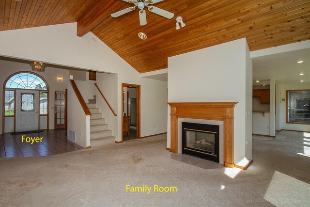 unfurnished living room with stairs, carpet, a fireplace, visible vents, and high vaulted ceiling