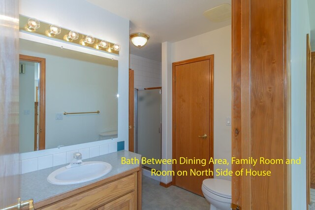 full bath with vanity, toilet, and an enclosed shower