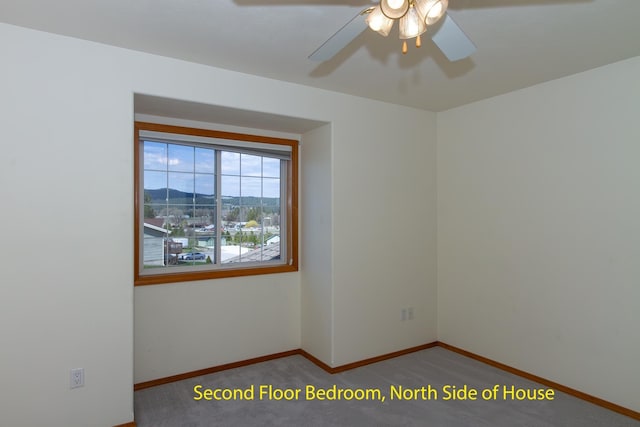 carpeted empty room with ceiling fan and baseboards