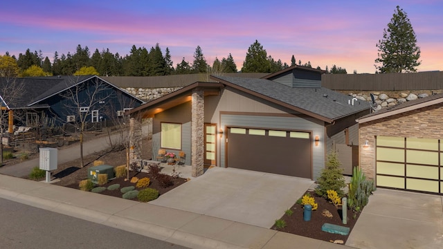 3306 N Ladalia Dr, Coeur D Alene, ID 83814 - view of front of home with a shingled roof, driveway, an attached garage, and stone siding