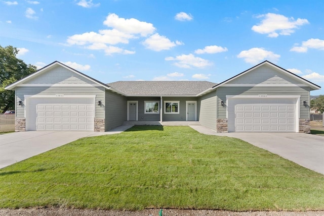 ranch-style home with stone siding, a front lawn, driveway, and an attached garage