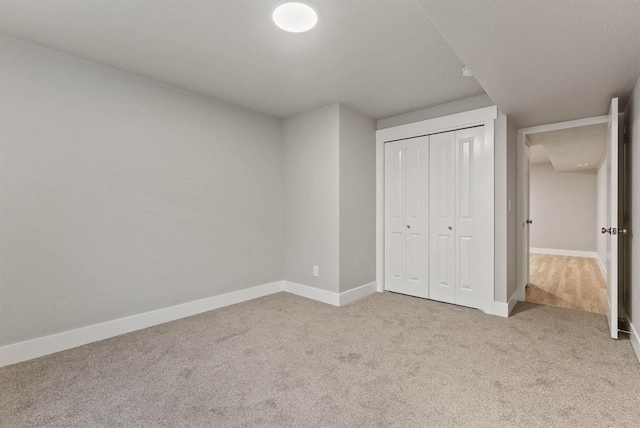 unfurnished bedroom featuring carpet, a closet, and baseboards