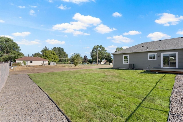 view of yard with central air condition unit and fence