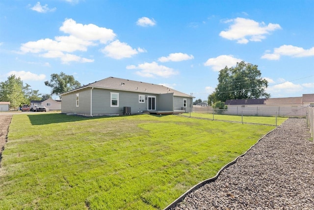 back of house featuring fence, a yard, and central air condition unit