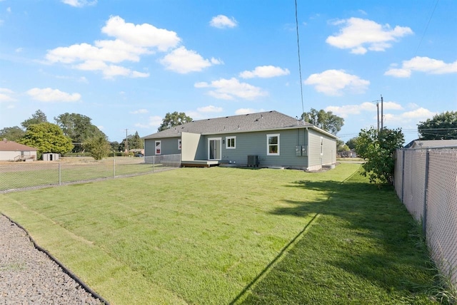 back of house featuring a fenced backyard and a yard