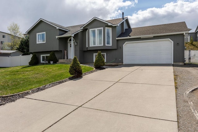 split foyer home with driveway, roof with shingles, fence, a front lawn, and a garage