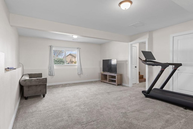 exercise room with baseboards and light carpet