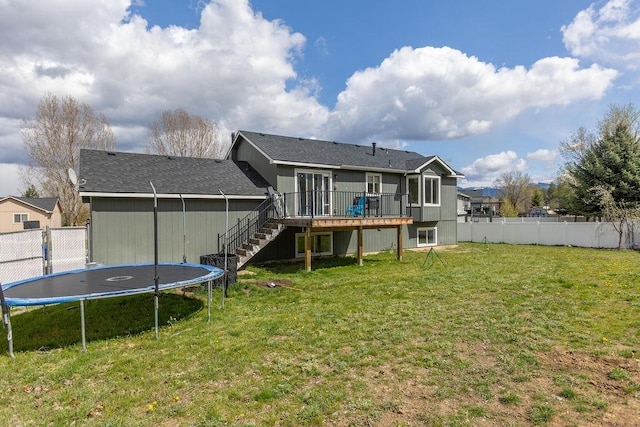 back of house with a deck, a trampoline, stairway, and a fenced backyard