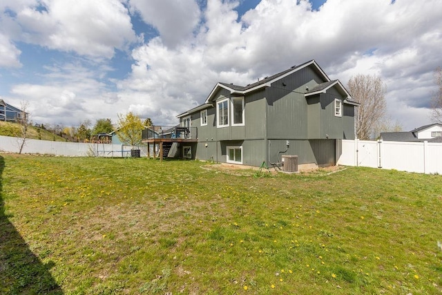 back of property with a wooden deck, a yard, stairway, and a fenced backyard