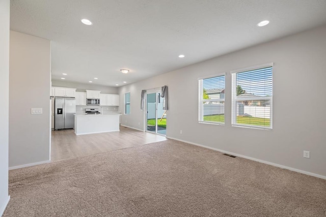 1102 S Best Rd, Spokane Valley, WA 99037 - unfurnished living room featuring light colored carpet and recessed lighting