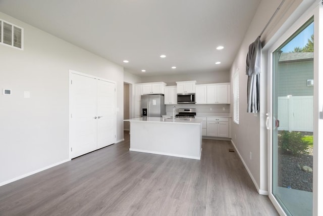 1102 S Best Rd, Spokane Valley, WA 99037 - kitchen featuring stainless steel appliances, wood finished floors, white cabinetry, an island with sink, and recessed lighting