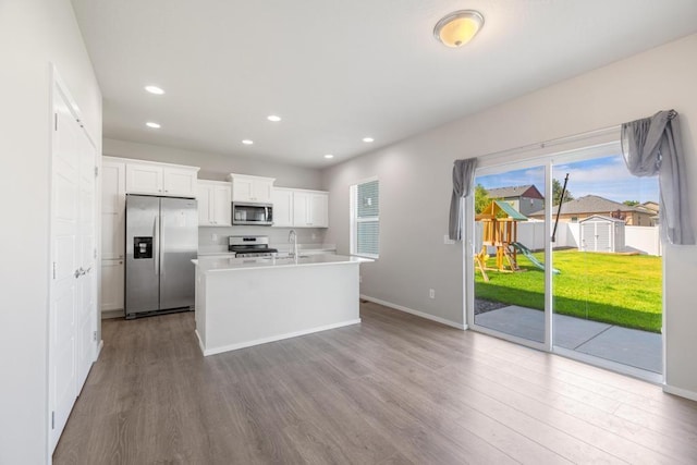 1102 S Best Rd, Spokane Valley, WA 99037 - kitchen featuring appliances with stainless steel finishes, wood finished floors, white cabinetry, a kitchen island with sink, and recessed lighting