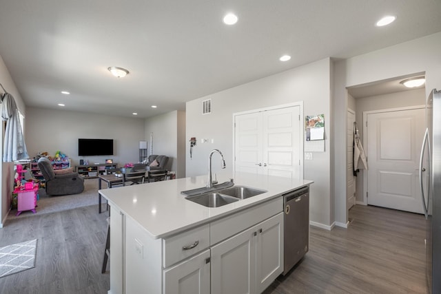 kitchen featuring wood finished floors, appliances with stainless steel finishes, light countertops, a sink, and visible vents