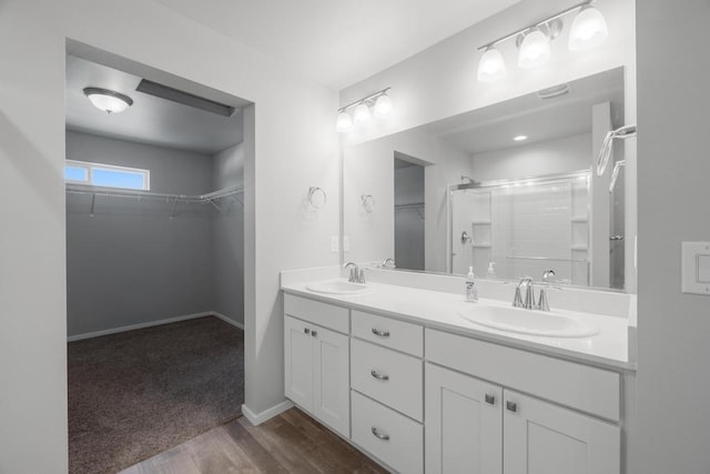 1102 S Best Rd, Spokane Valley, WA 99037 - bathroom with a shower stall, double vanity, a walk in closet, and wood finished floors