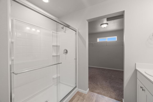1102 S Best Rd, Spokane Valley, WA 99037 - full bath featuring a shower stall, vanity, a walk in closet, and wood finished floors