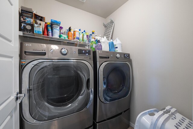 clothes washing area featuring washing machine and clothes dryer and laundry area