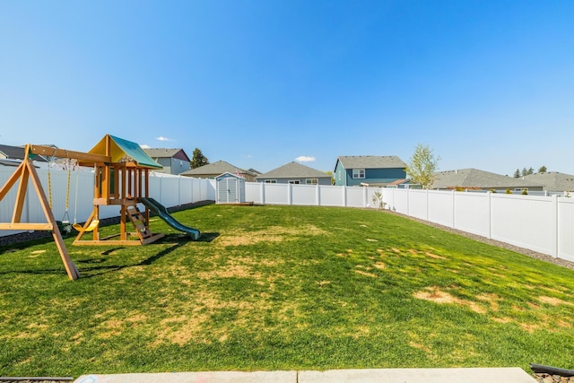 view of yard with an outdoor structure, a fenced backyard, a storage shed, a residential view, and a playground