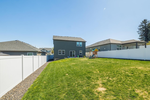 view of yard with a fenced backyard and a playground