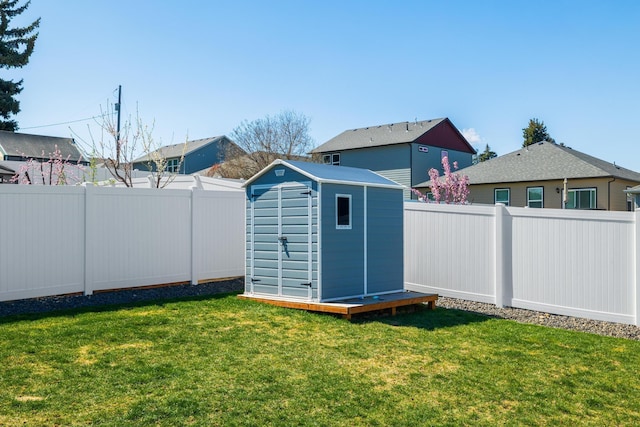 view of yard featuring an outbuilding, a storage unit, and a fenced backyard