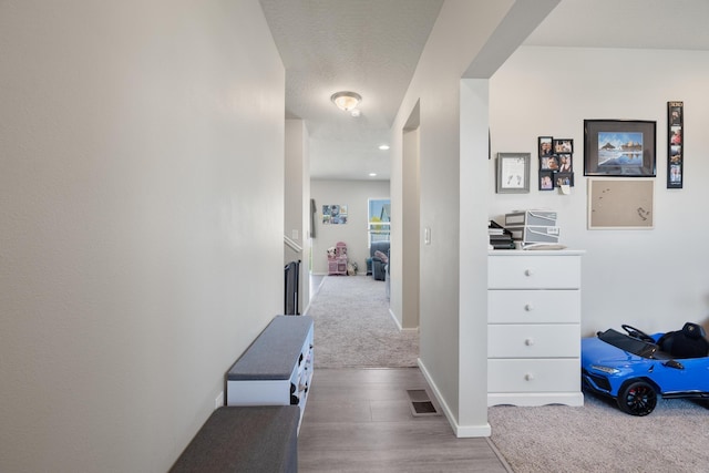 hall featuring recessed lighting, visible vents, carpet, and baseboards