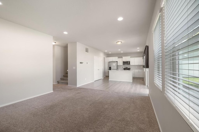 1102 S Best Rd, Spokane Valley, WA 99037 - unfurnished living room with light colored carpet, recessed lighting, and stairway