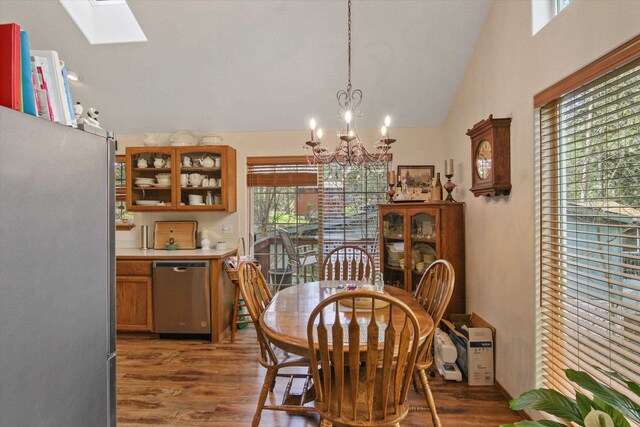 9306 E Lake Rd, Elk, WA 99009 - dining area featuring a notable chandelier, a healthy amount of sunlight, wood finished floors, and vaulted ceiling with skylight