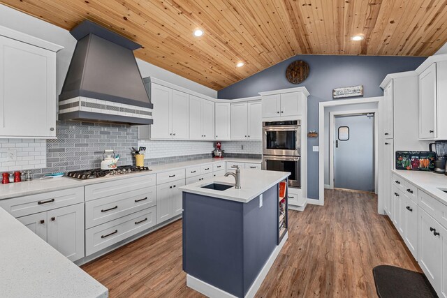 kitchen featuring custom exhaust hood, a sink, stainless steel appliances, and light countertops