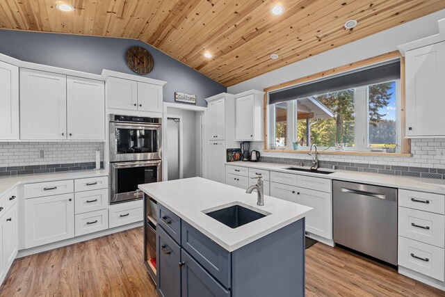 kitchen with lofted ceiling, a sink, wooden ceiling, and stainless steel appliances